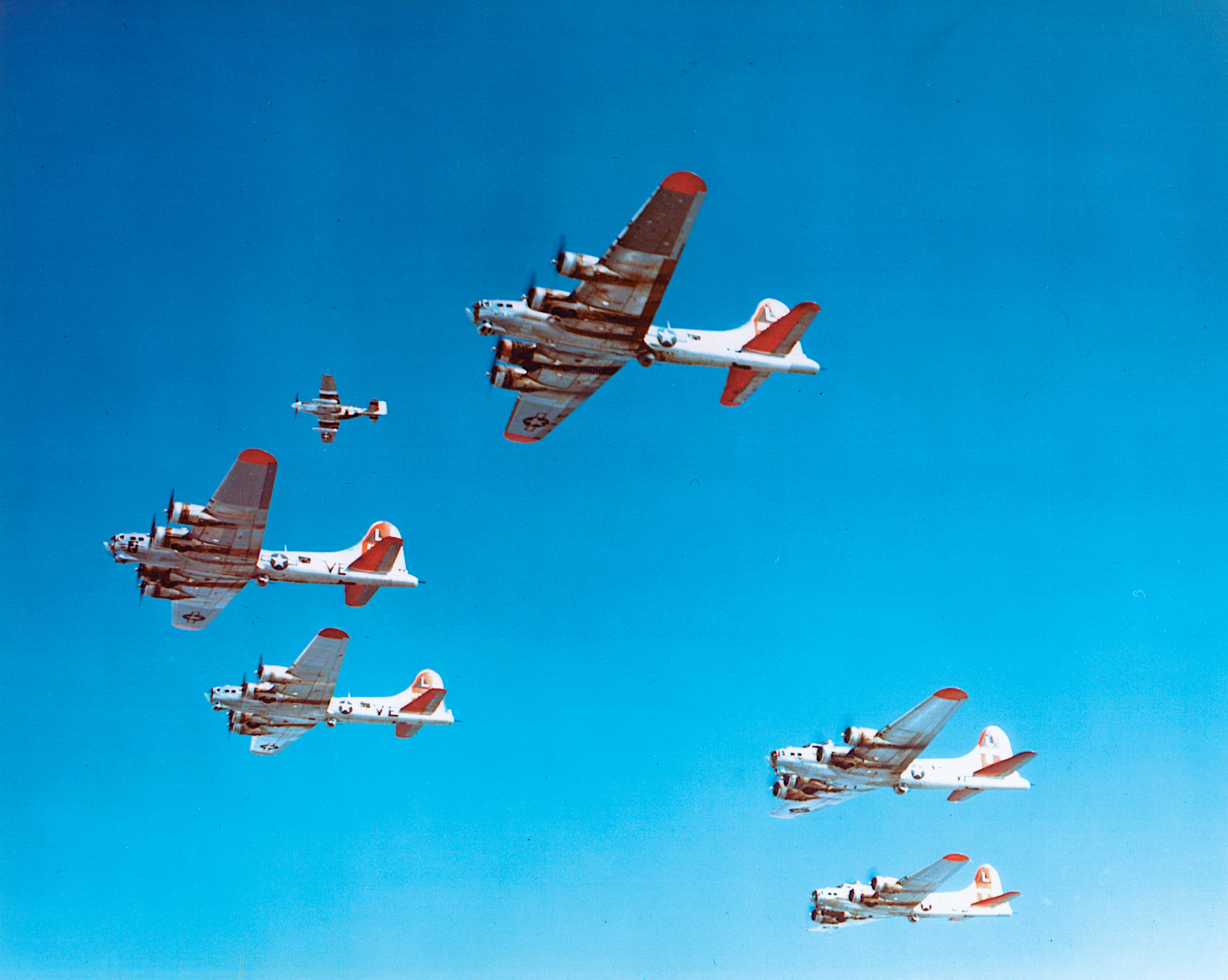 B-17s of the Eighth Air Force fly over England with a P-51 joining the group.