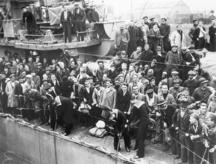 Liberated in a daring raid, British merchant seamen crowd the decks of HMS Cossack during the voyage home.