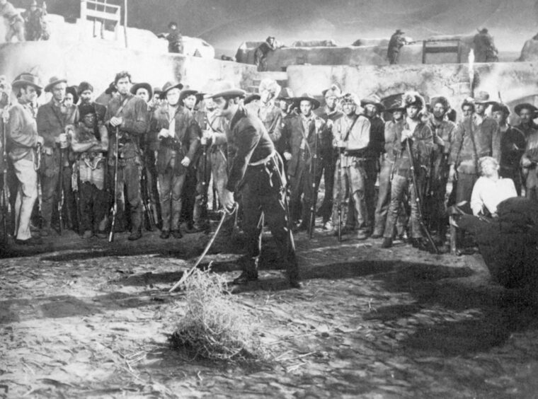 A scene from the 1955 Davy Crockett, King of the Wild Frontier shows William Travis marking his line in the sand. 
