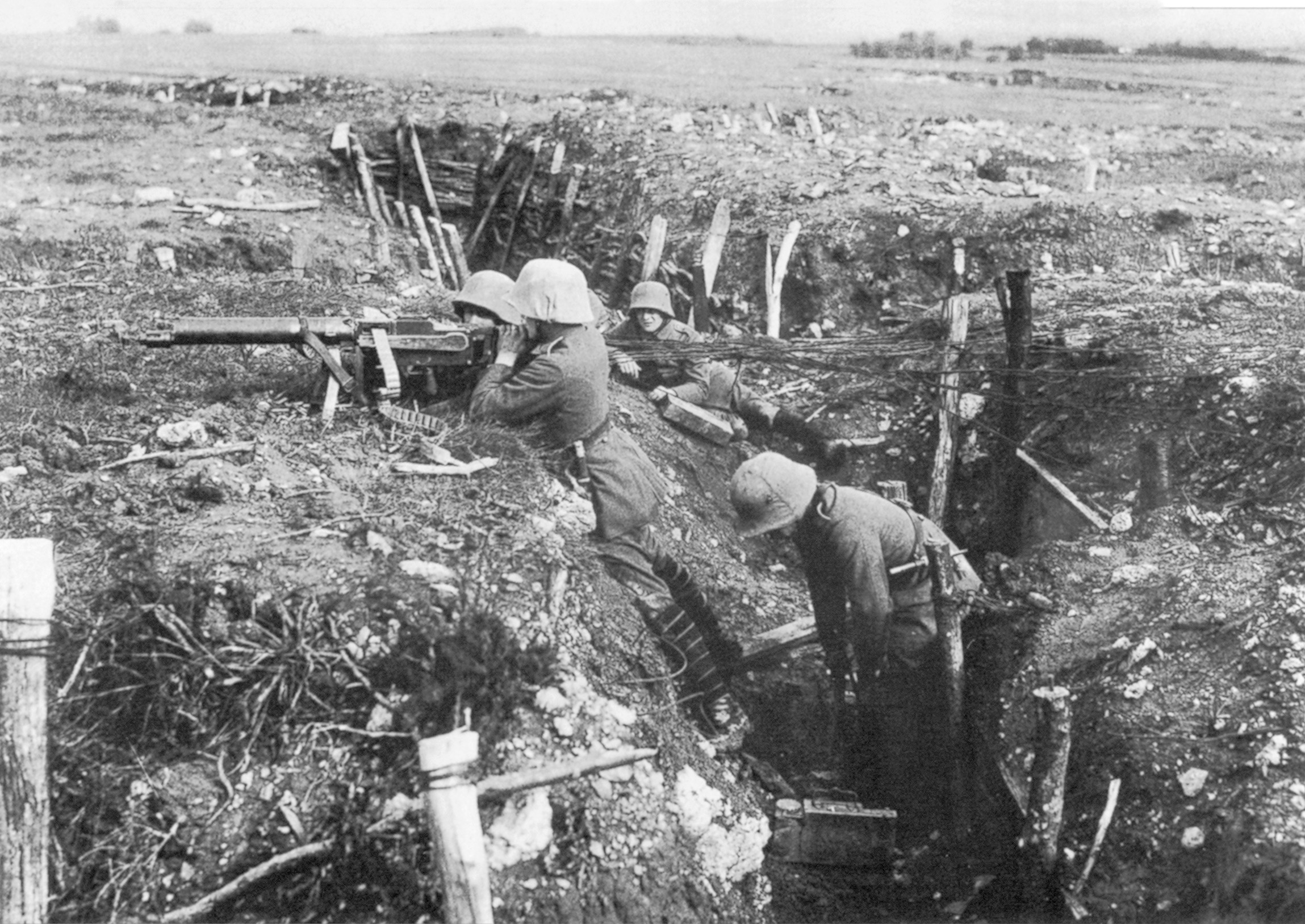 German troops stand guard with a light machine gun. Two men operate the gun and two are ready with ammunition boxes.