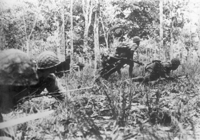 Japanese soldiers, bayonets at the ready, creep forward in their advance on Kohima. The 15th Army was meant to overrun the British supply stations and march into the heart of India.
