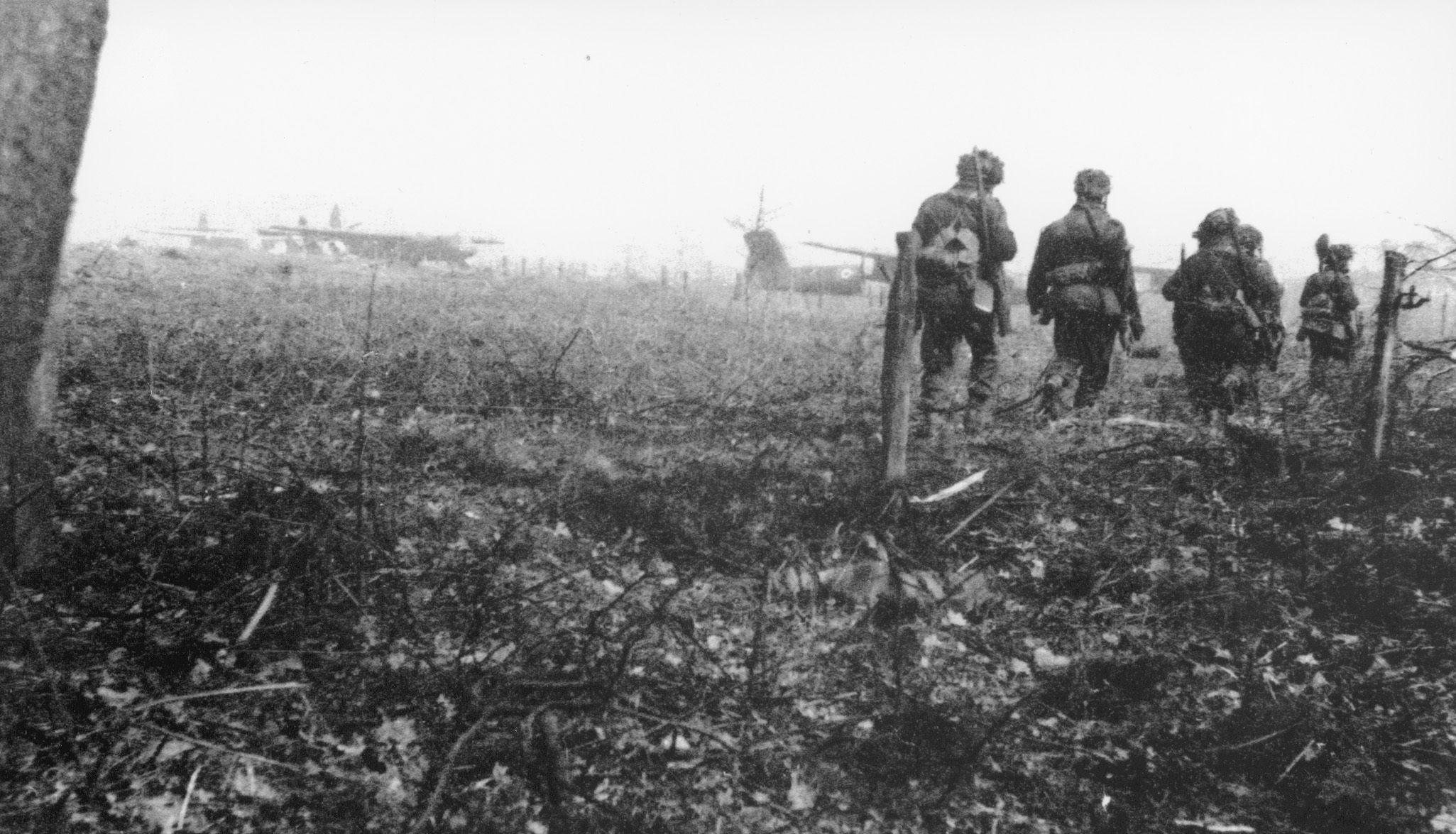 Paratroopers move along the edge of a drop zone after the fighting had ceased.