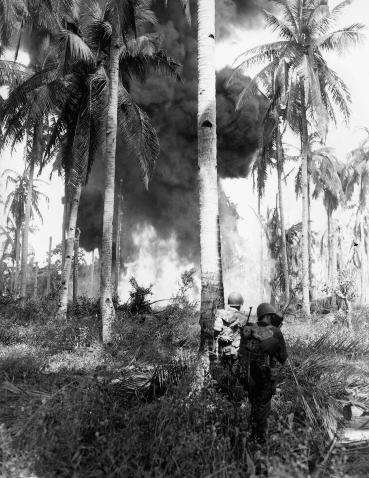 A Japanese fuel dump, hit by U.S. naval gunfire prior to the landings on Leyte by the U.S. 1st Cavalry Division, goes up in flames.