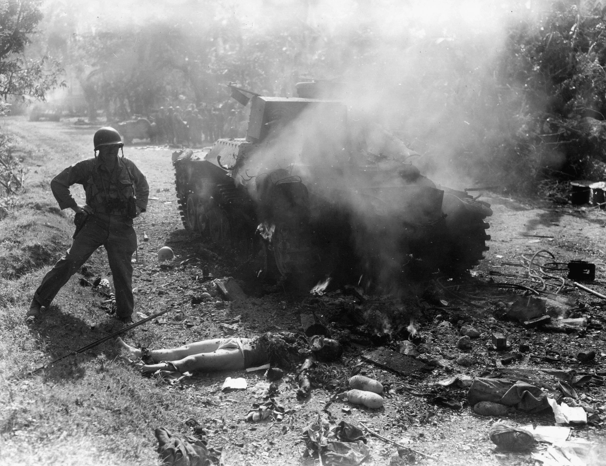 A Japanese tank, knocked out by infantrymen of the 43rd Division, smolders on a dirt road on January 17, 1945.