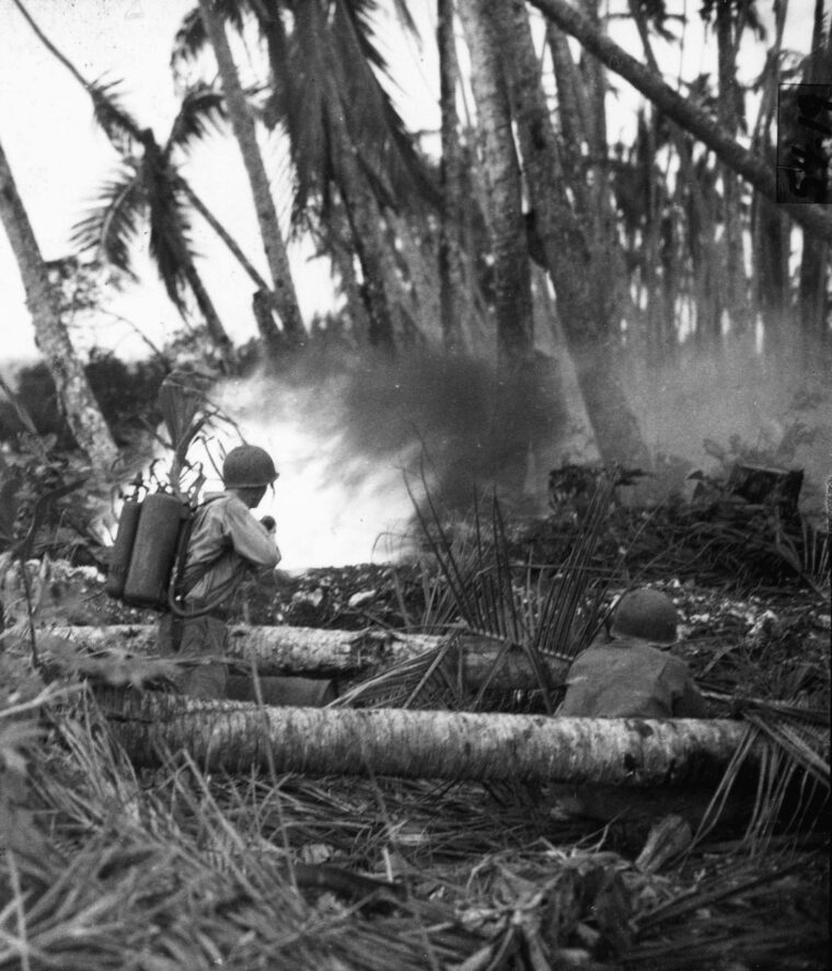 An American soldier of the 43rd Infantry Division unleashes a deadly stream from his flamethrower during efforts to silence a Japanese pillbox.