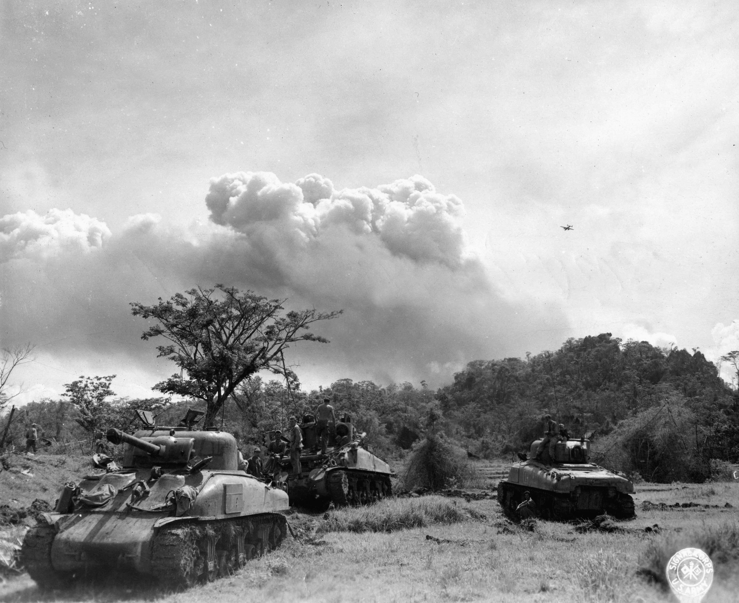On the heels of an air strike, Sherman tanks of the 754th Battalion prepare to attack Japanese positions in the area of the Ipo Dam on Luzon.