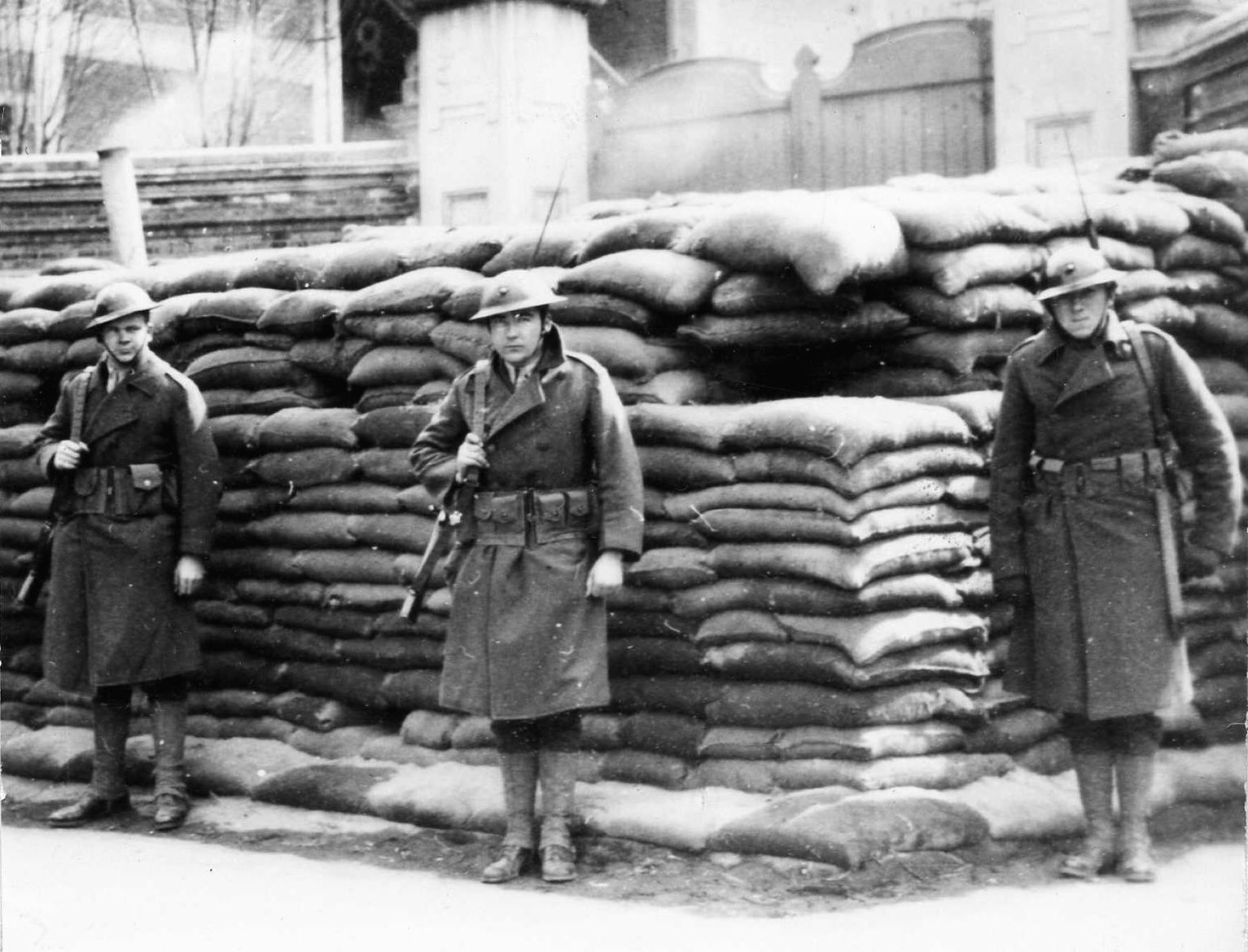 In 1932, a detachment of well-armed Marines from the cruiser USS Houston stands watch in front of a sandbagged blockhouse at the Ichang Ros Bridge in Shanghai.