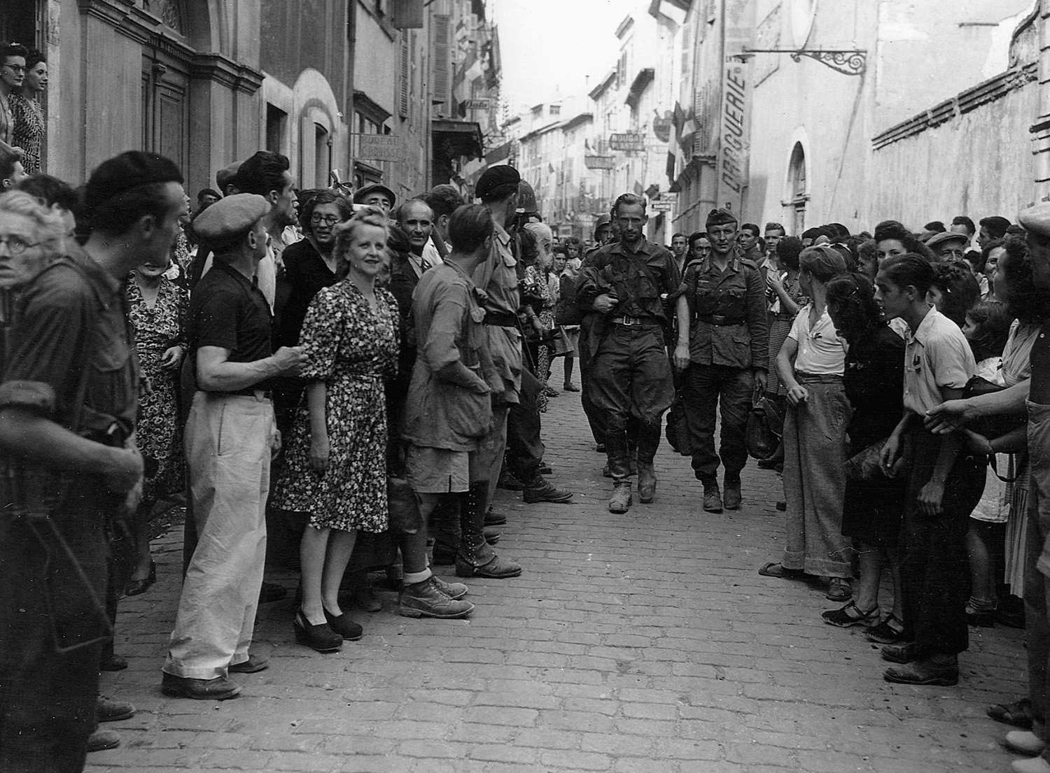Captured German snipers are marched down a street before a crowd of onlooking citizens in Montelimar.
