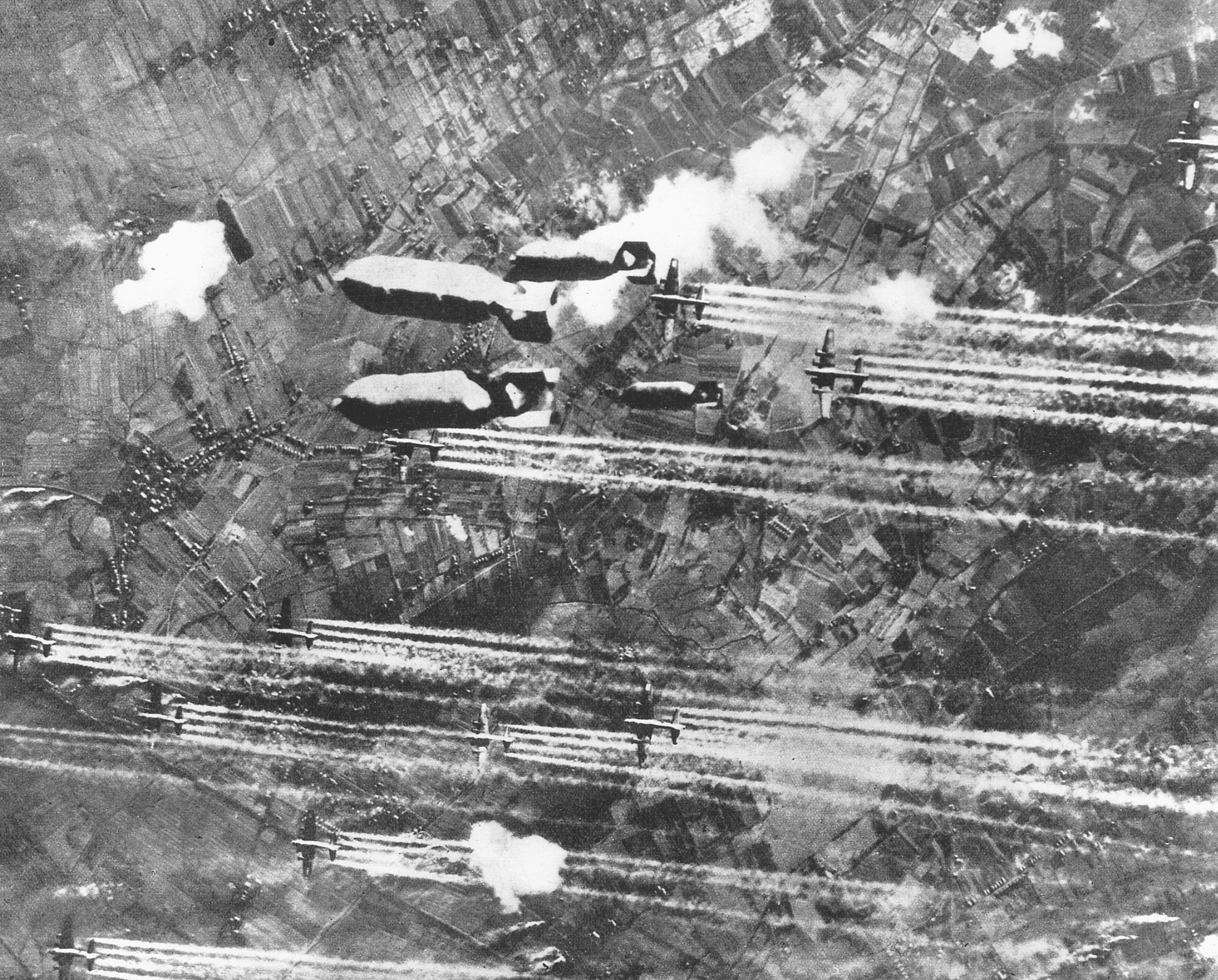 Numerous flak explosions shower U.S. B-17 bombers as they drop a hailstorm of bombs on the Focke-Wulf aircraft factory in Bremen. 