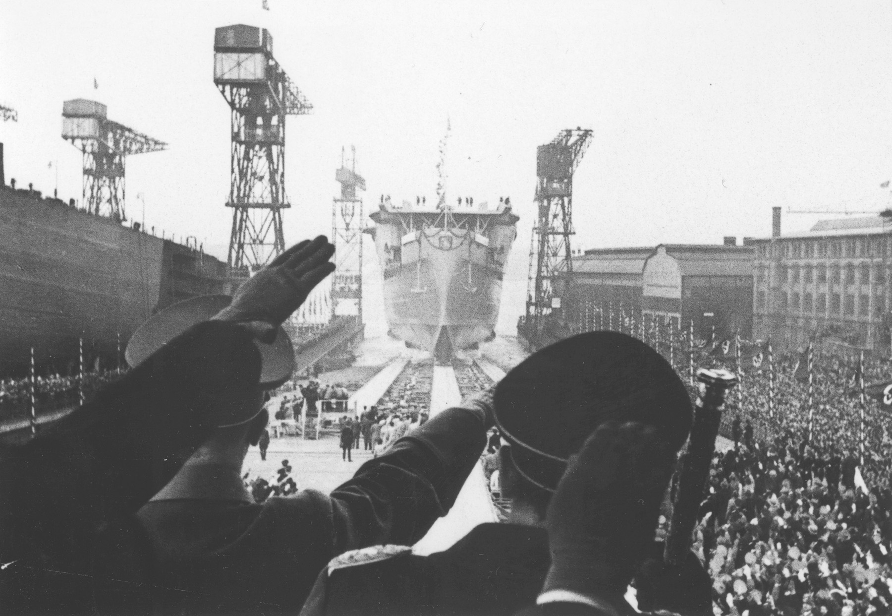 Chancellor Adolf Hitler and Reichsmarshal Hermann Göring salute as Graf Zeppelin is launched at Kiel’s Germania shipyard.