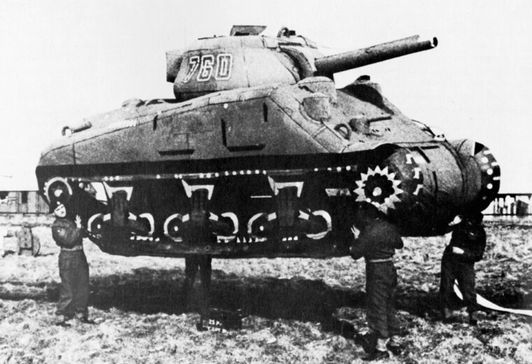  British soldiers hoist an inflatable tank used in the D-day hoax. Working in unison with the false information provided by German double agents, the tank was part of a decoy invasion force meant to draw German defenses away from Normandy. 