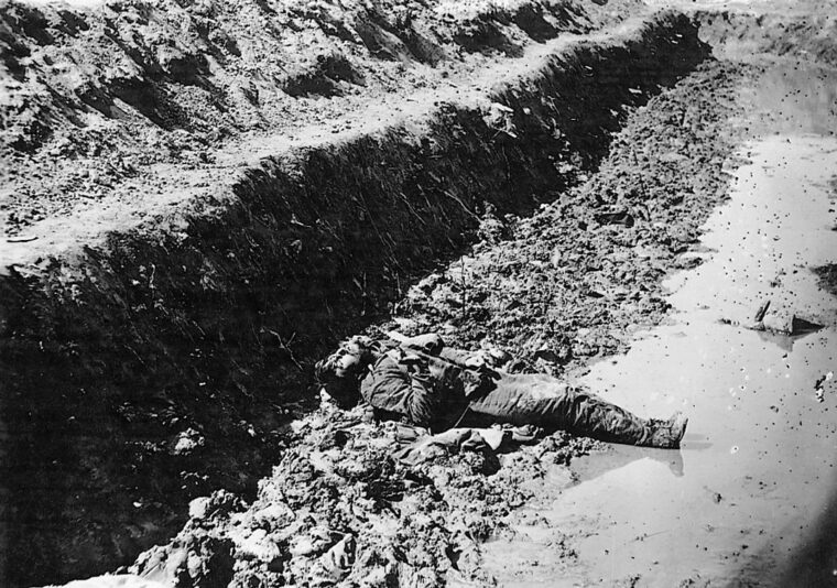 A dead confederate soldier lies amid the muck of Petersburg’s trenches.