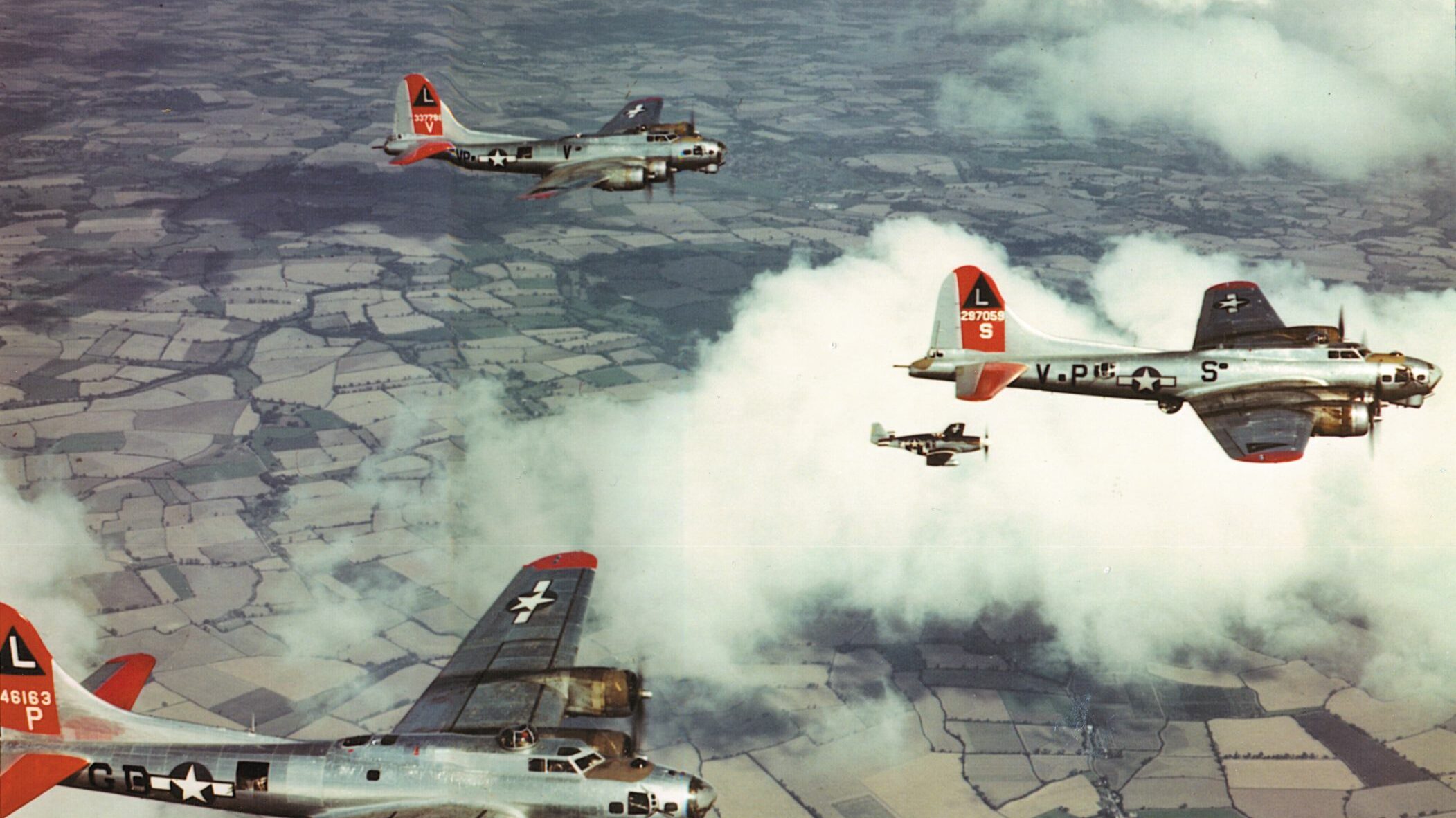 B-17s of the 8th Air Force, accompanied by fighters, cruise over England.