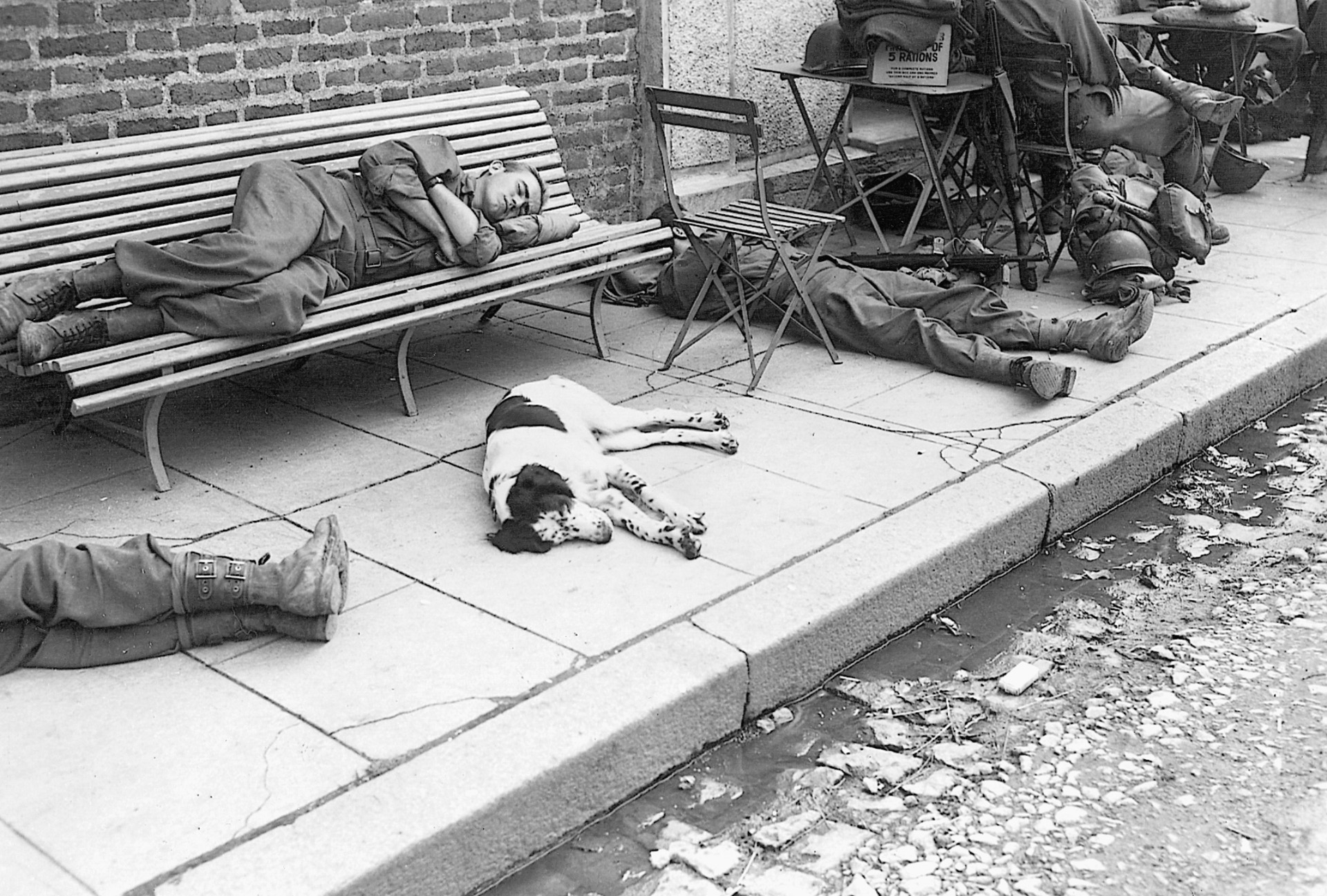 Soldiers with the 6th Armored Division catch a few winks on the outskirts of the burning town of Waldkappel, Germany.