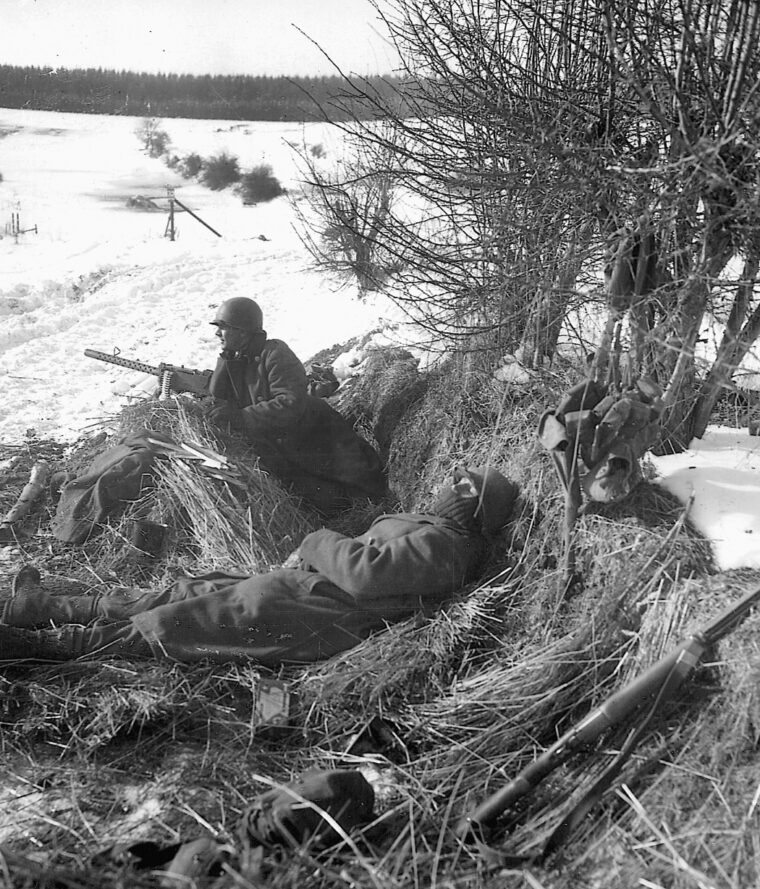 With his partner keeping watch, an infantryman of the 2nd Armored Division sleeps shortly after the liberation of Houffalize, Belgium. 