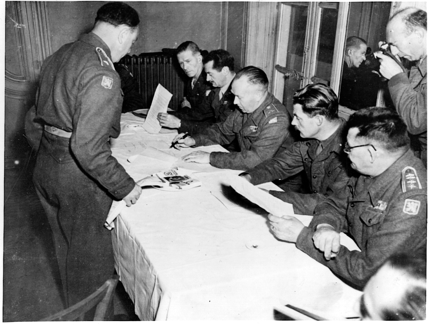 British officers discuss the terms of surrender to be offered to the German command in the war-ravaged French city of Dunkirk. Located on the English Channel, Dunkirk had been the scene of a humiliating defeat and the evacuation of the British Expeditionary Force from the continent of Europe in 1940.