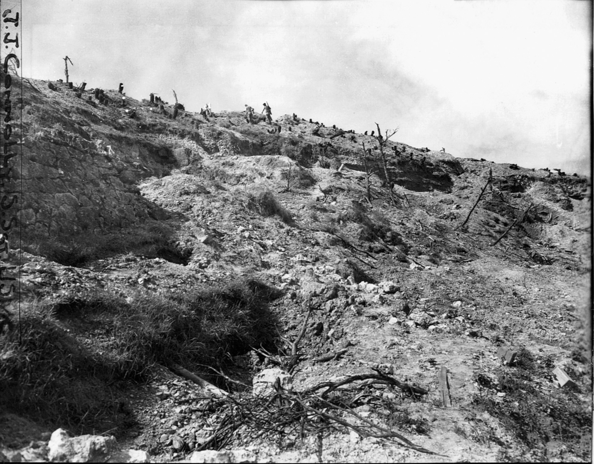 Battle weary Marines slowly ascend Sugar Loaf Hill after its capture.