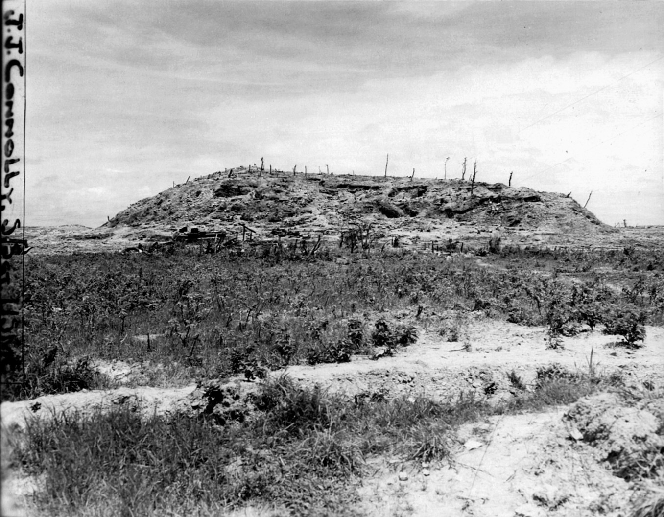 The desolate visage of Sugar Loaf Hill looms in the distance of this photograph. U.S. troops experienced bitter fighting at Sugar Loaf as a run of good luck came to an abrupt end.