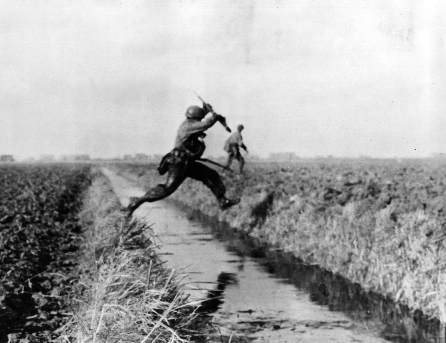 Rapidly moving across the low-lying Dutch countryside, an American soldier leaps over a drainage ditch. After the initial phase of Operation Market Garden, the fighting in Holland became more protracted.