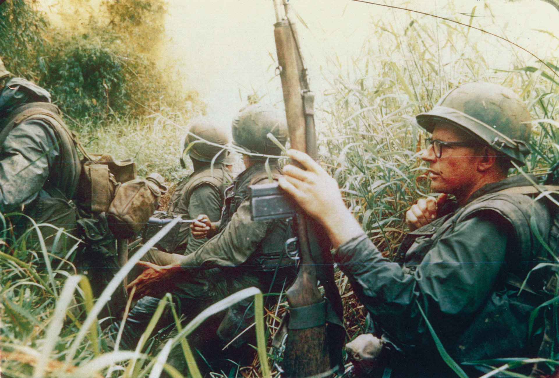 Wary of ever-present danger, members of 3rd Platoon’s E Company keep on the alert as they move through a trench before crossing a bamboo bridge near Con Thien.