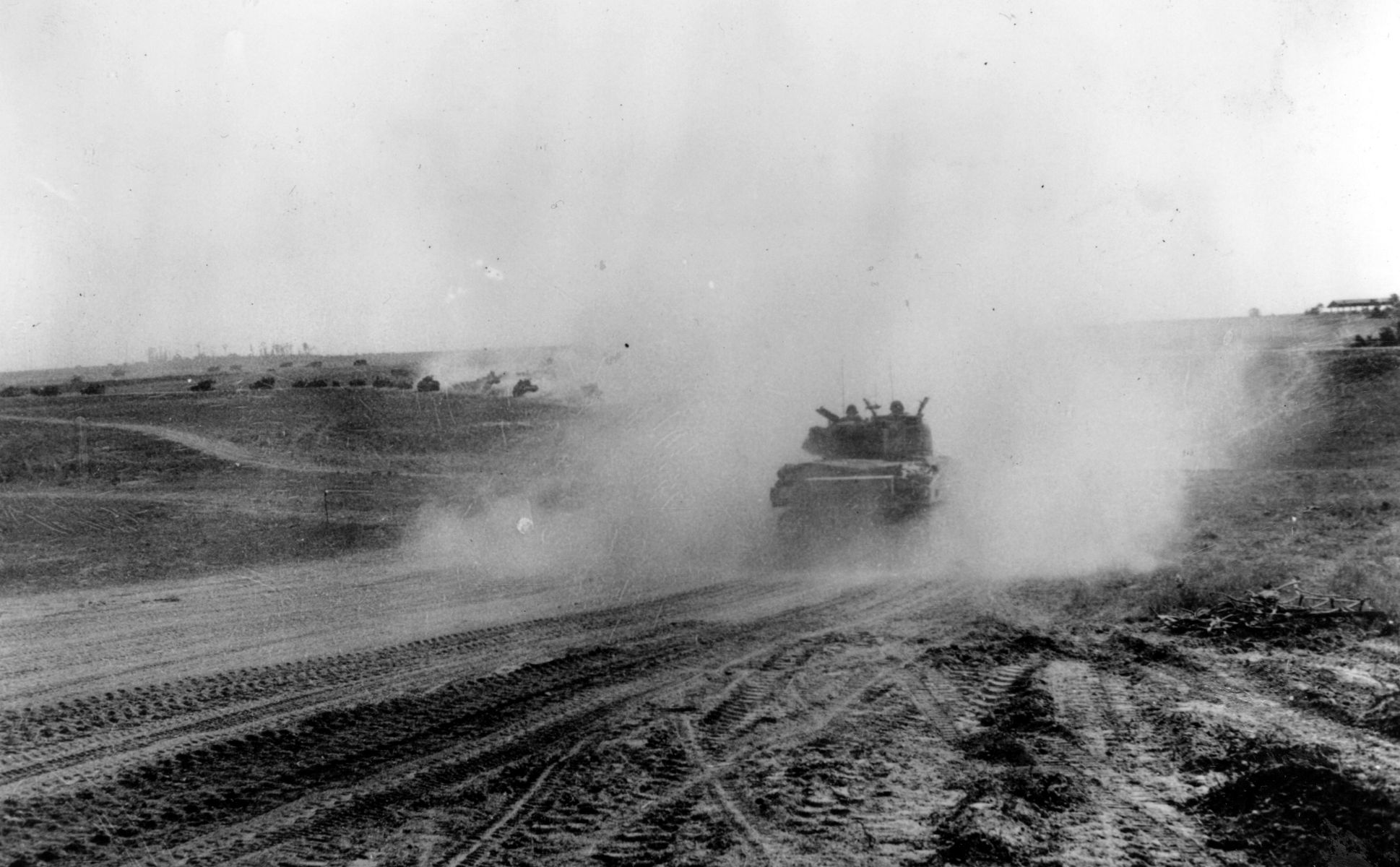 Canadian armored forces raise a cloud of dust as they take up battle positions in the drive to Falaise in August 1944.
