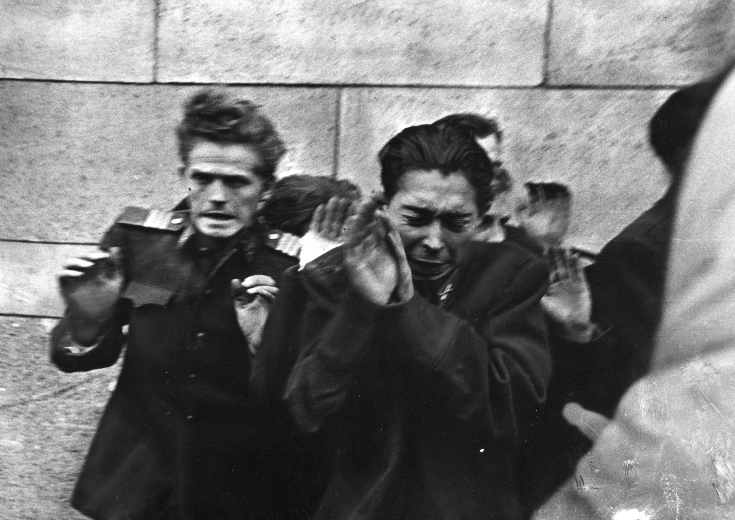 AVH secret policemen, hands raised to protect themselves, are gunned down by Hungarian rebels. 