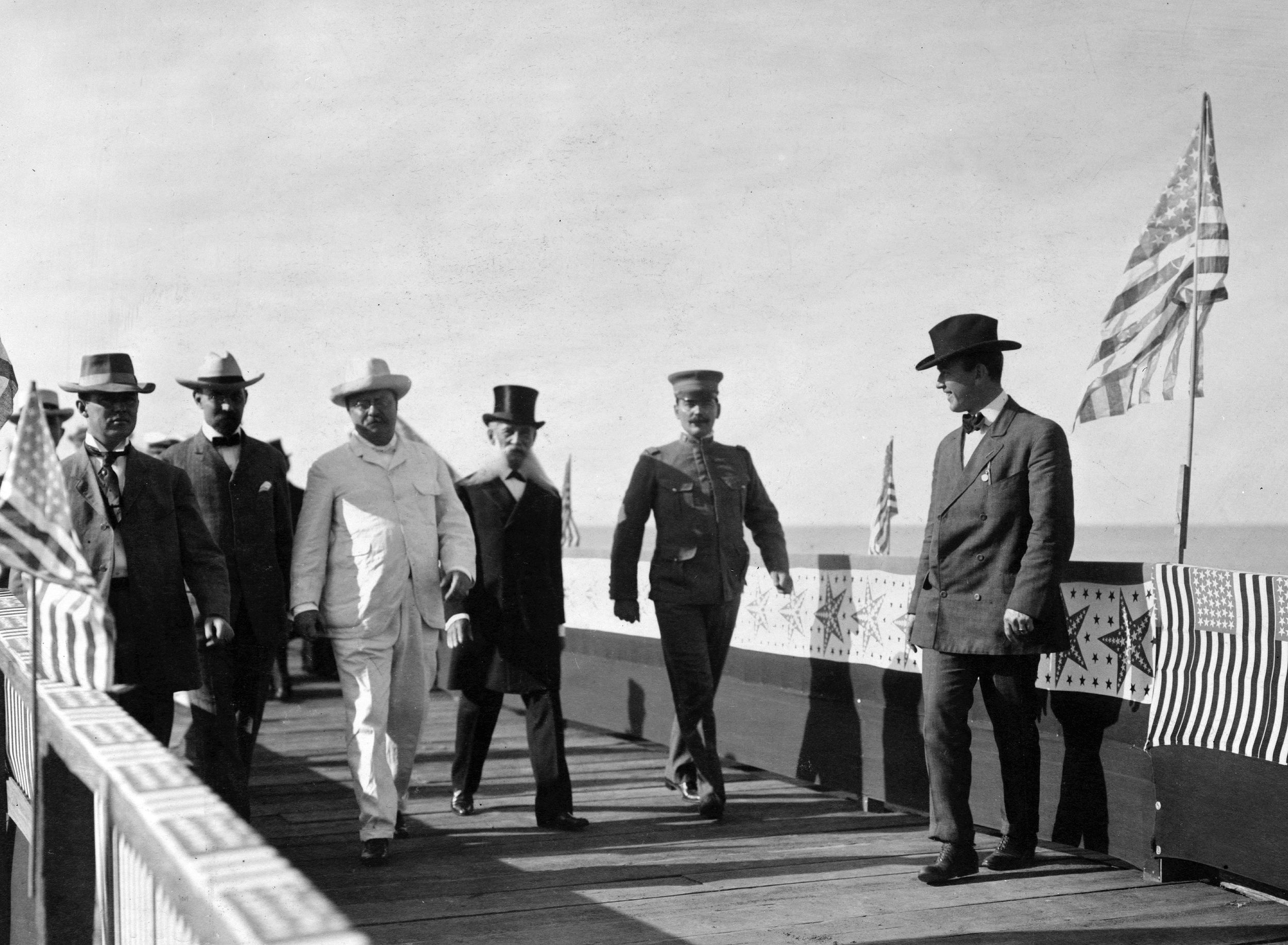 President Theodore Roosevelt leads a gaggle of soldiers and diplomats on an impromptu inspection of the American fleet.