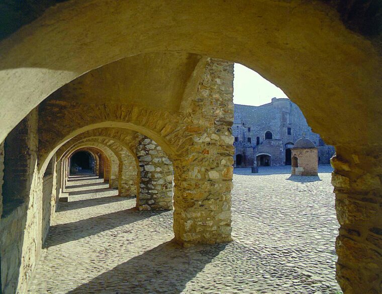 The common is organized around a four-sided courtyard with archways providing access to chapel, barracks, and stables. 
