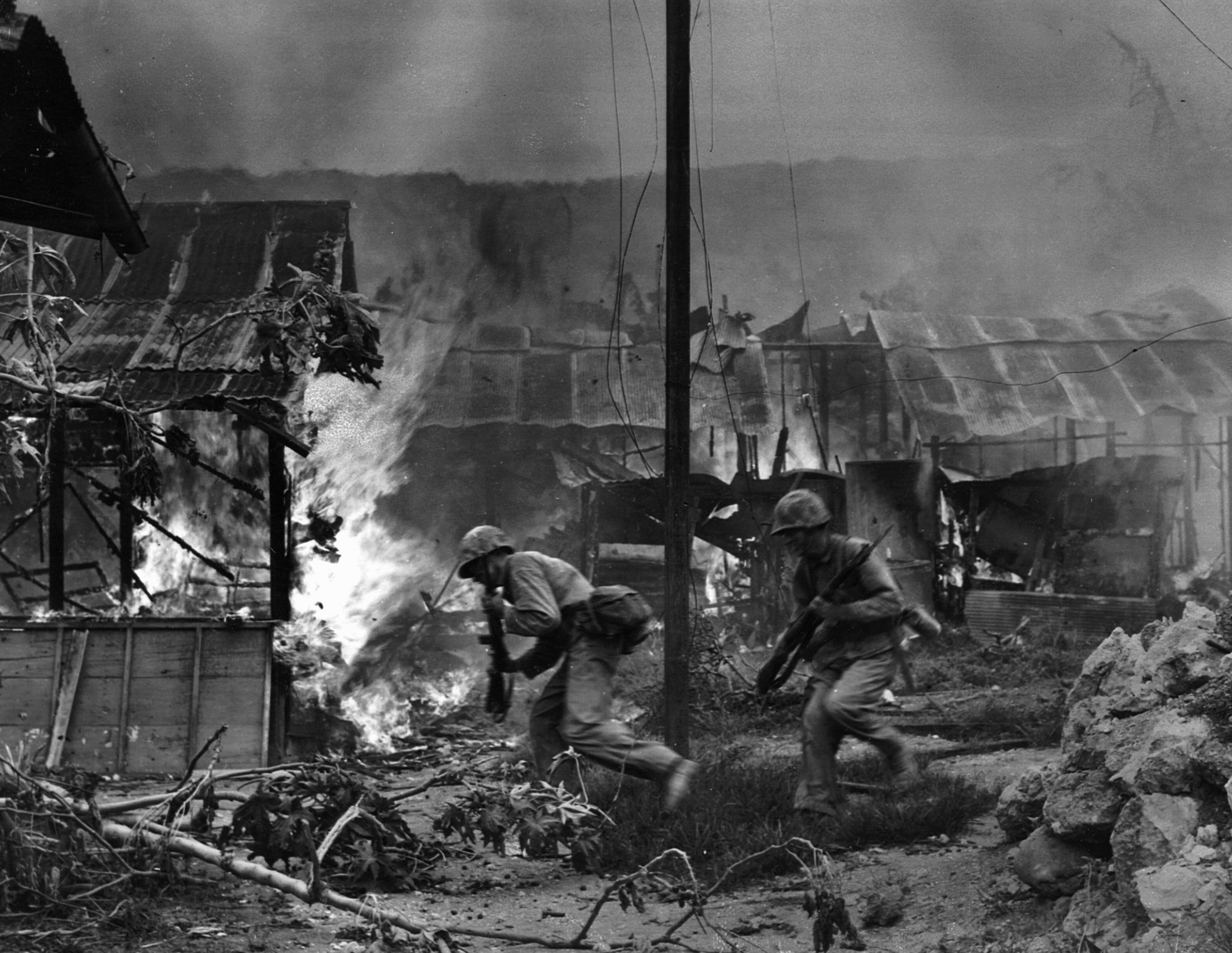 Enveloped in smoke and flame, Marines enter the town of Garapan on July 1, 1944.