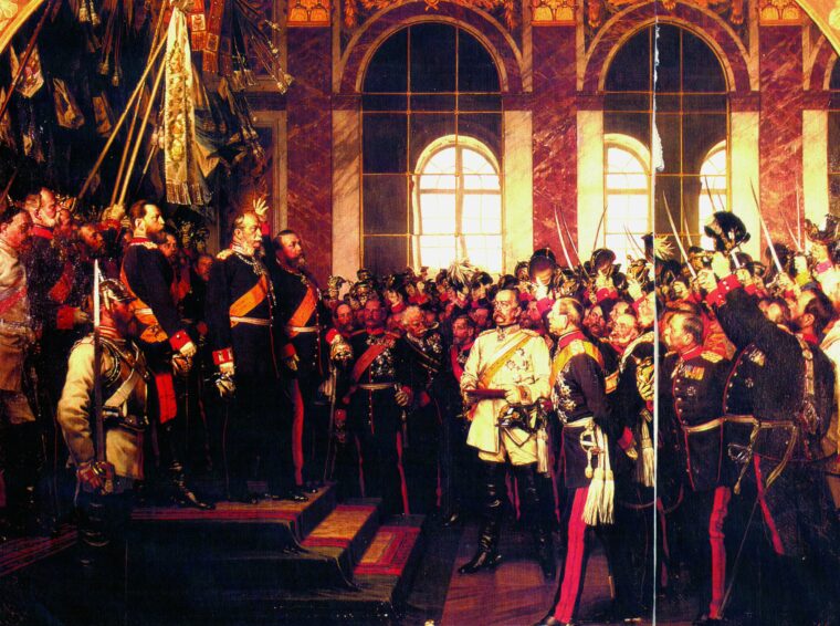 Kaiser Wilhelm I, standing on the dais, proclaims a new German empire in the Hall of Mirrors at Versailles on January 18, 1871. He is flanked by Crown Prince Frederick Wilhelm and the Grand Duke of Baden. Otto von Bismarck stands at the base of the steps in a white uniform.