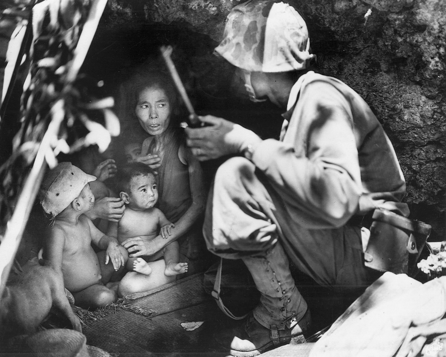 A young Marine attempts to reassure terrified Japanese civilians.