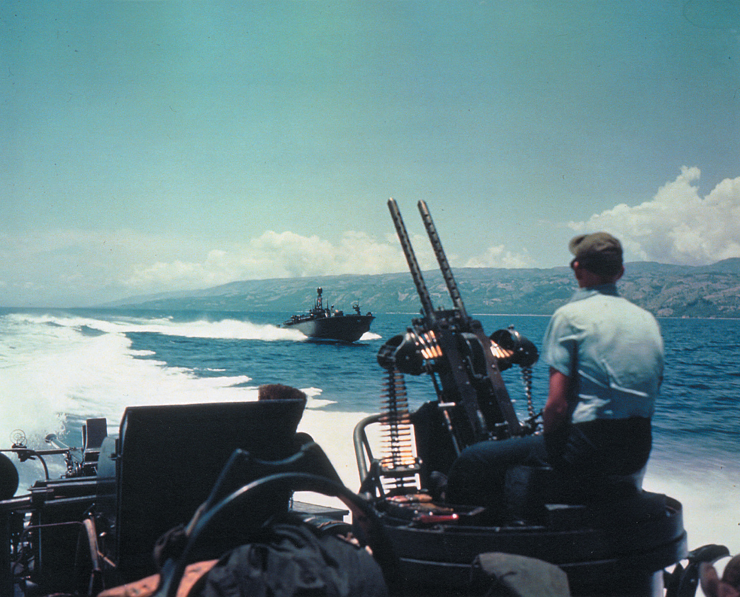 U.S. PT boats patrol a long stretch of shoreline in the Pacific. 