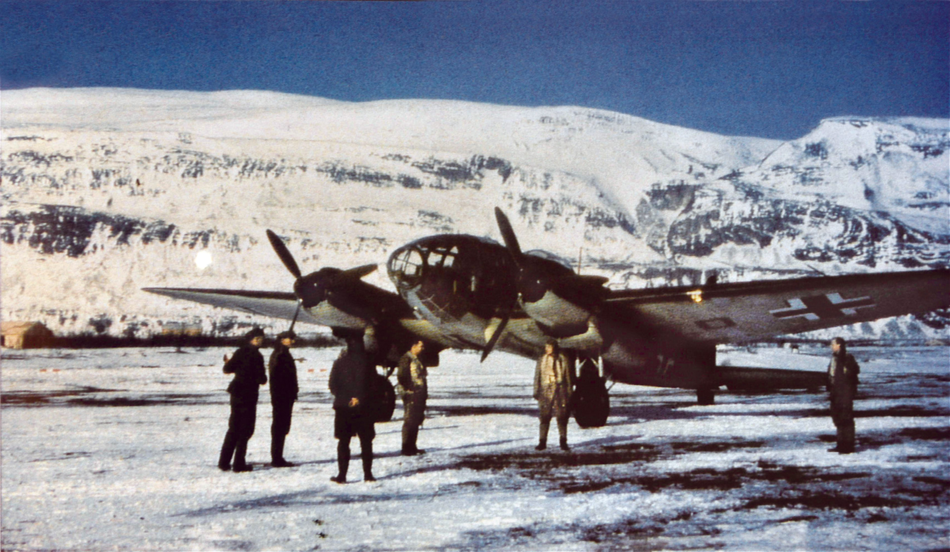 First Lieutenant Rudolf Schutze of Wekusta 5 and his flight crew gather near a Heinkel He-111weather aircraft on the ice of Advent, Fjord.