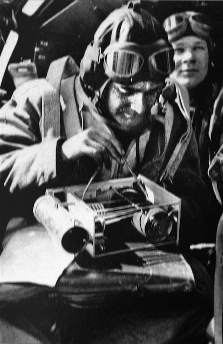 Helmut Rau, seated in the observer position aboard a Heinkel He-111 reconnaissance plane, takes weather readings. 