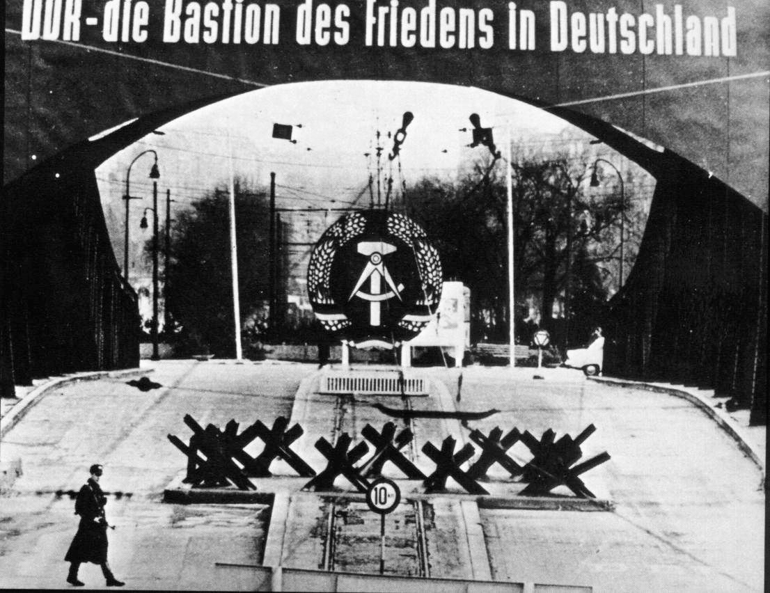 A propaganda poster proclaims: “DDR—Bastion of the Free in Germany.”