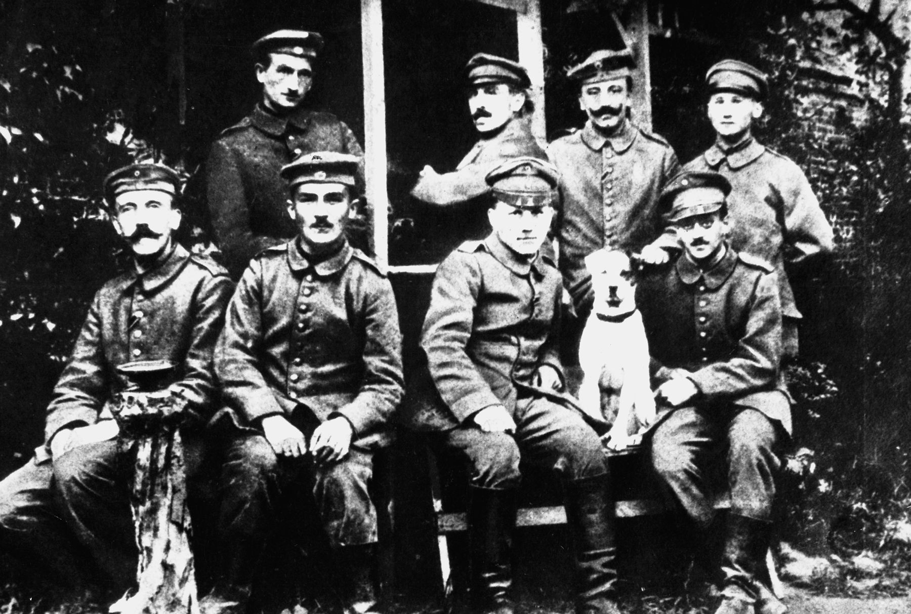 Corporal Hitler, far left, poses with a group of fellow soldiers and their mascot, Foxy, at the front.