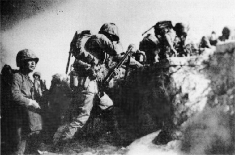 The Marine in the foreground carries a 12-gauge M1912 riot shotgun with cut-down pistol grip.