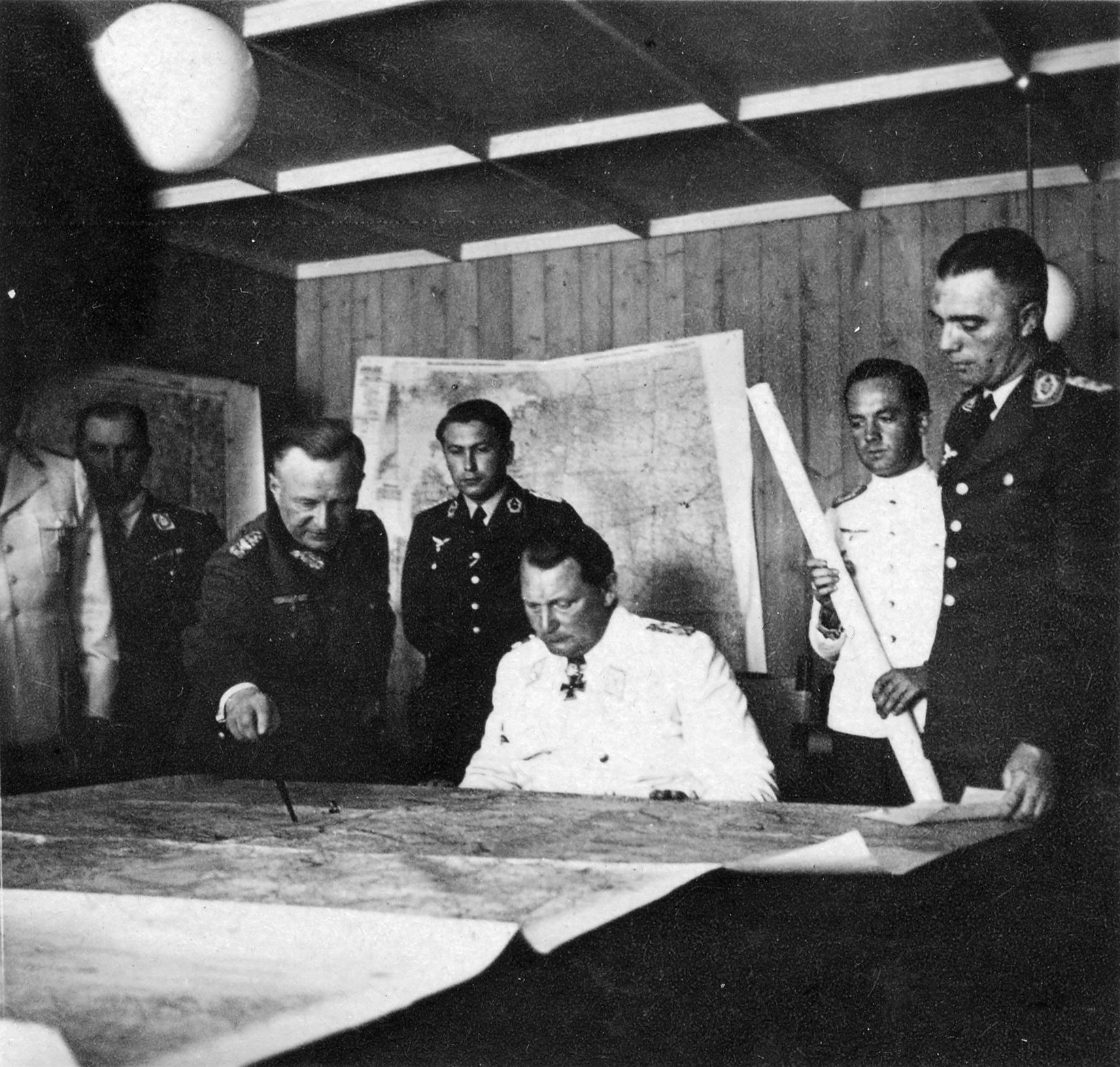 The Reichsmarschall studies the map table during a briefing by generals at his headquarters.