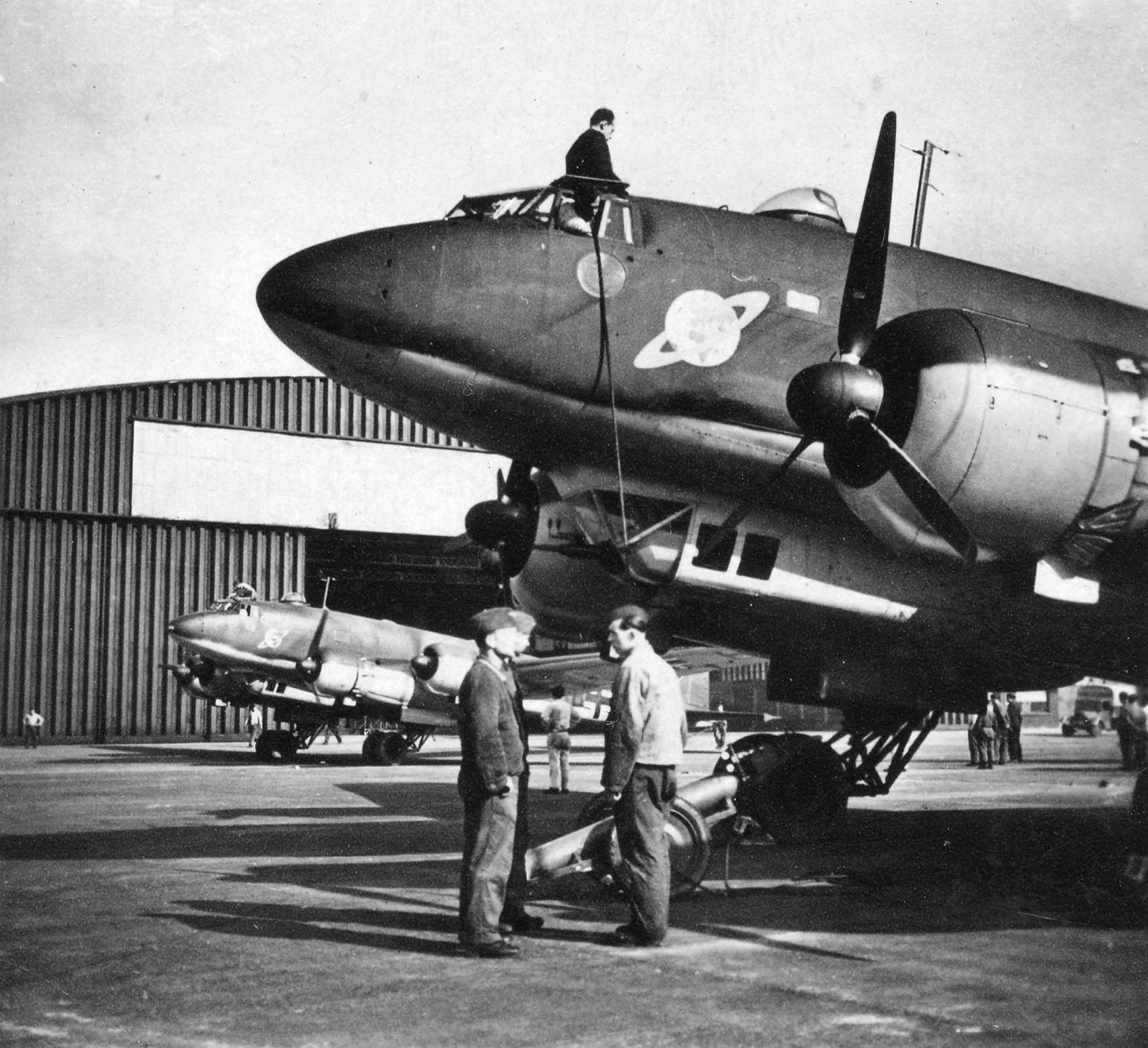 Airmen prepare for a reconnaissance flight. Note the squadron emblem of the Earth with Saturn-like rings around it.