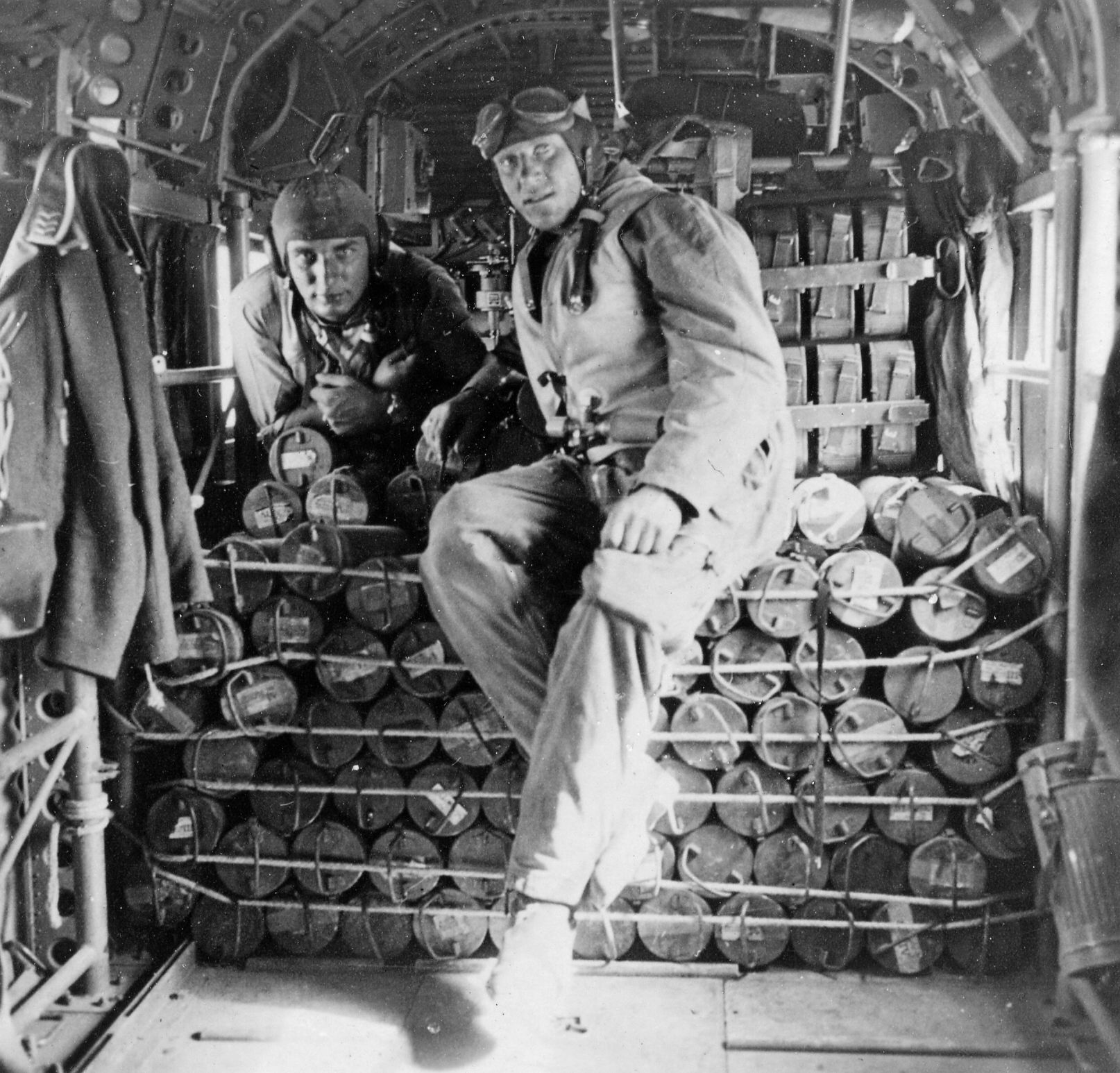 Inside the cabin of a Junkers Ju-52 transport plane being loaded with bombs.  