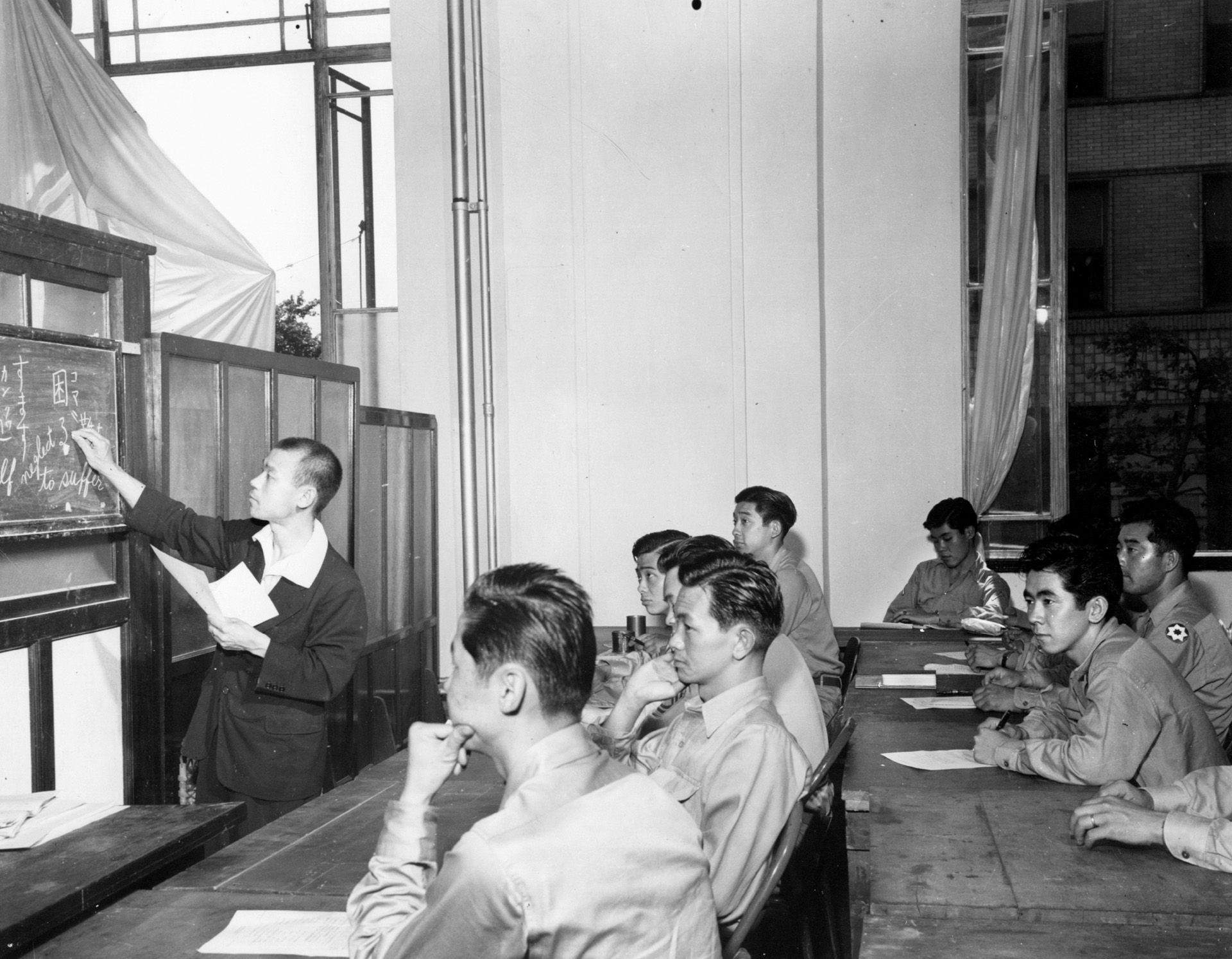 Attending a class in legal terminology as part of a training program to improve their knowledge of the Japanese language, Nisei soldiers serving as interpreters of the linguist section or the translator and interpreter section pay attention to an instructor. This photo was taken in September 1946, at General Headquarters, Allied Powers in the Pacific, Tokyo.