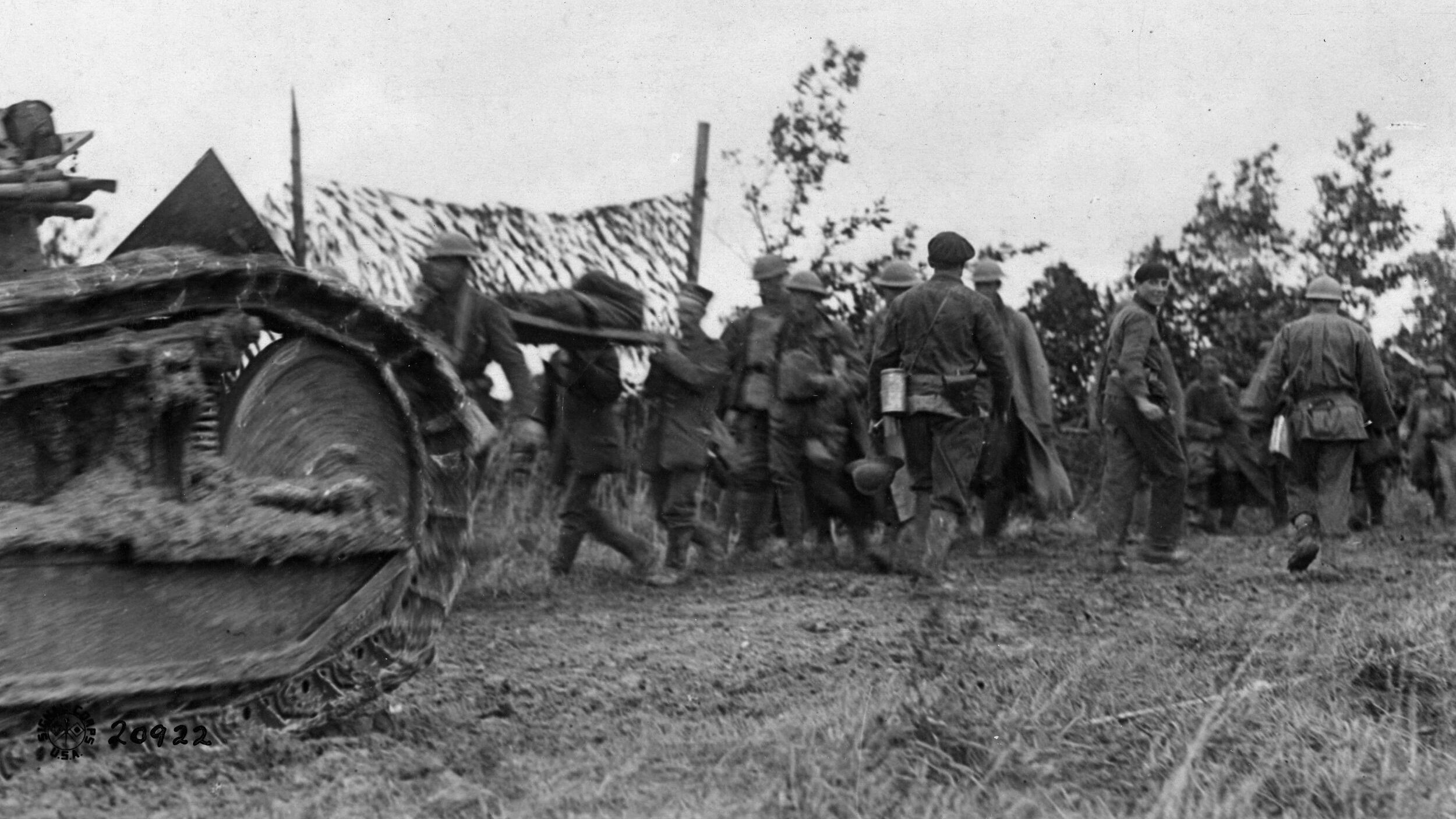 An American tank moves to the front past German prisoners carrying their wounded to the rear on the first morning of the attack at St. Mihiel.