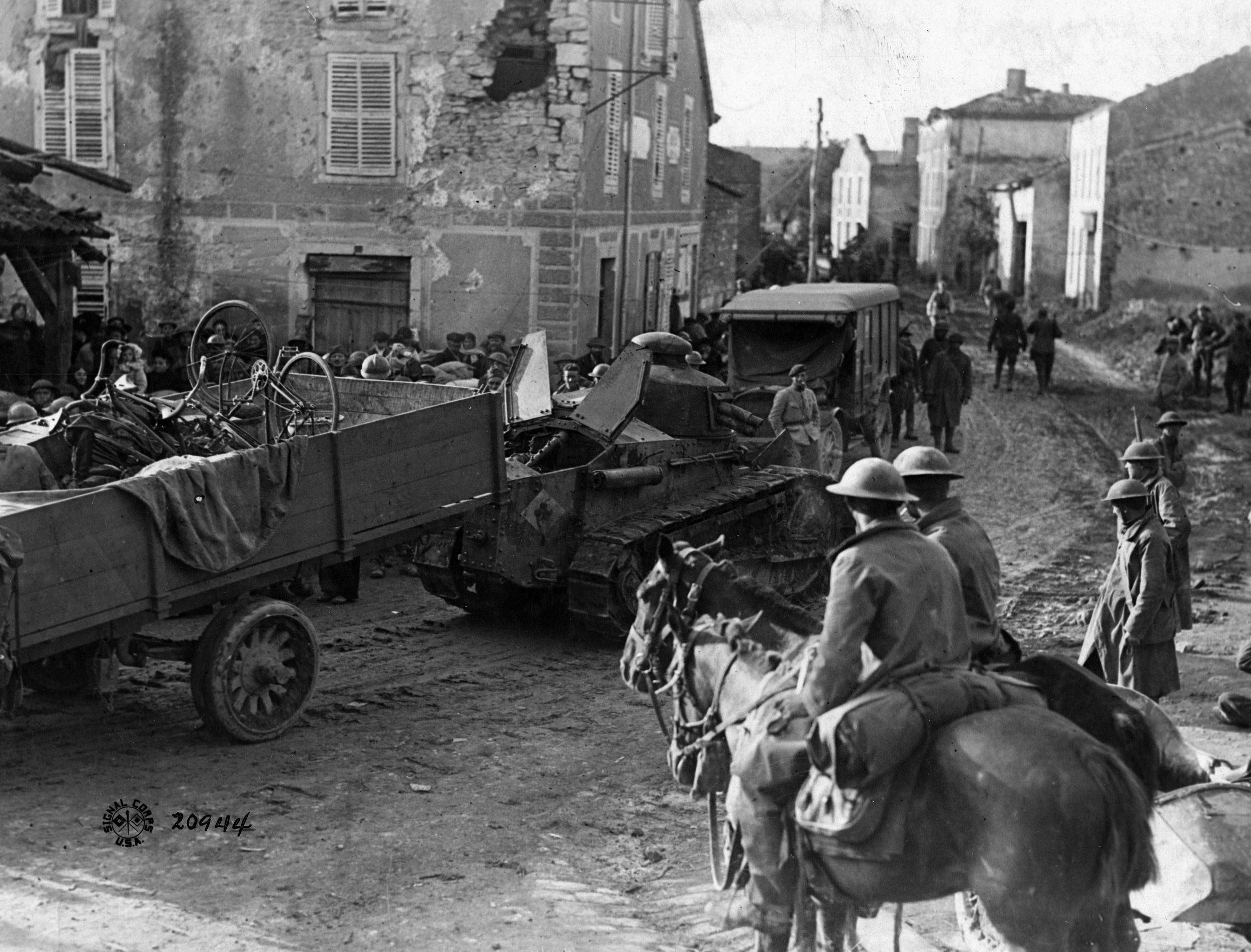 A tank joins a mixed convoy of vehicles and horses at Essey, France.