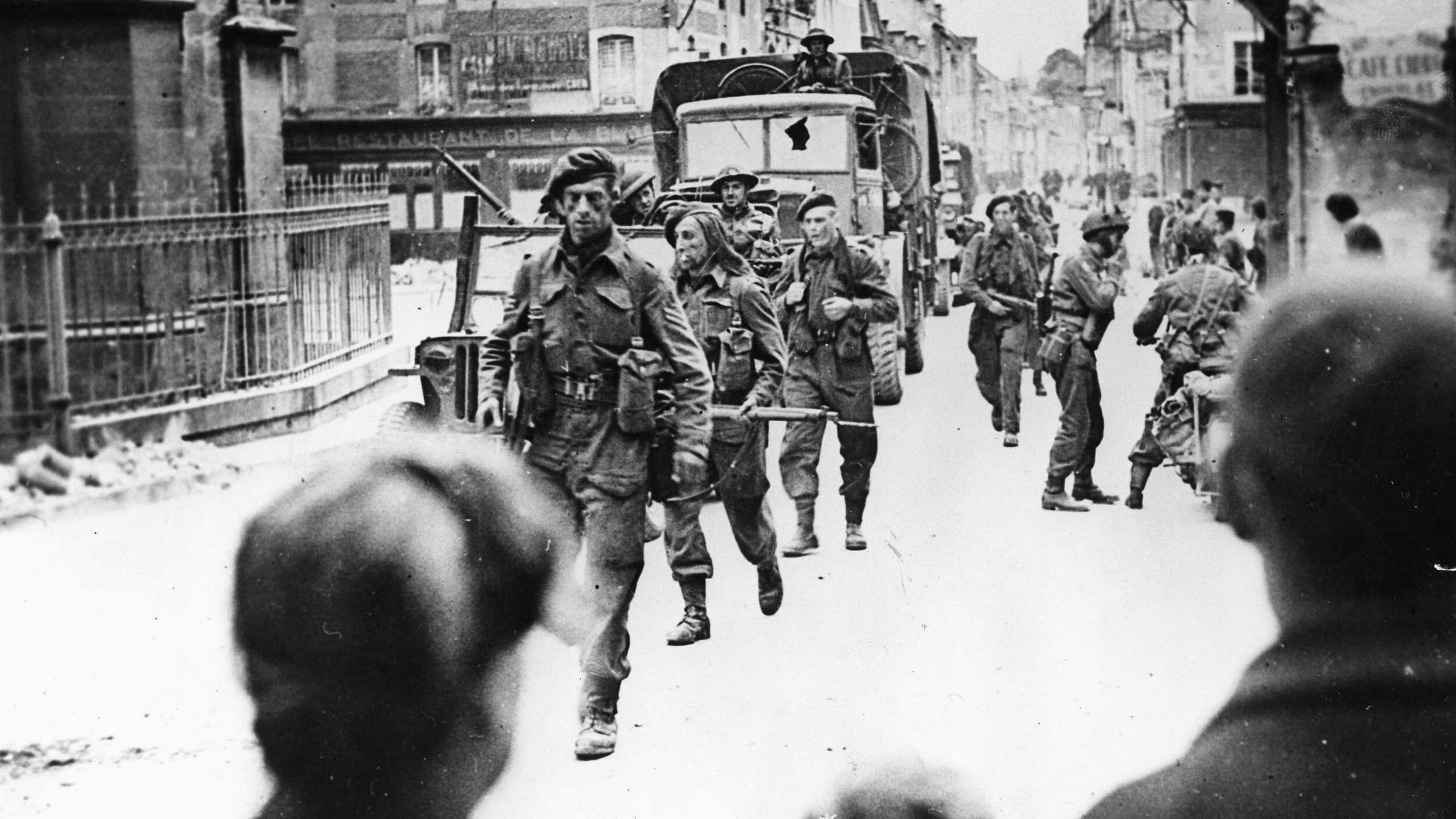 British commandos march through the ruins of the French town of Caen. An objective of the Allied D-Day landings that was supposed to have been captured on June 6, stiff German resistance prevented the city from being liberated until a month later.