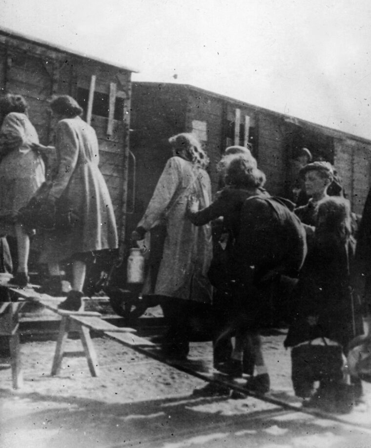 Jewish women and children board cattle cars during their evacuation from the Warsaw Ghetto in 1944. The destination of this train was the Treblinka concentration camp and, for most, extermination.