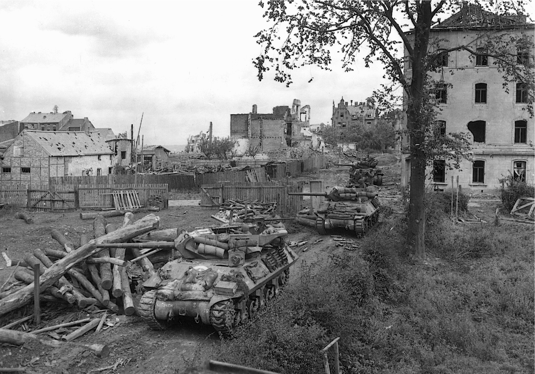 Near Aachen on October 14, 1944, open-turreted American M-10 tank destroyers fire on German observation posts in preparation for an assault and to prevent the ranging of German artillery. (National Archives)