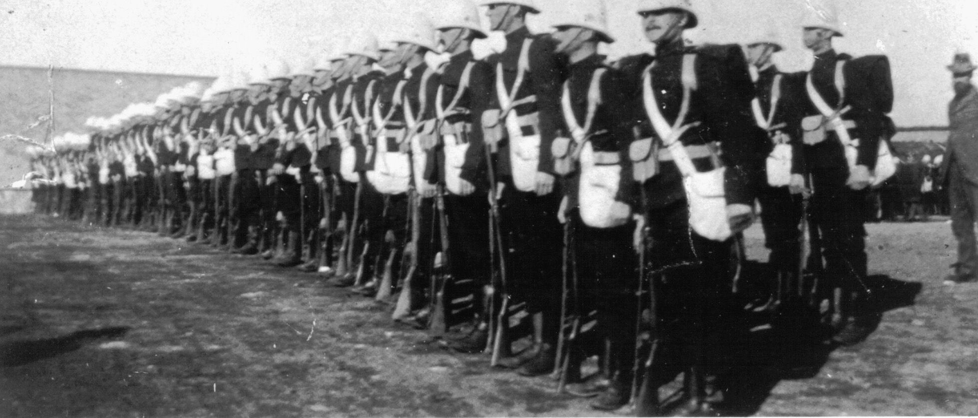 Members of D Company stand at attention on parade.