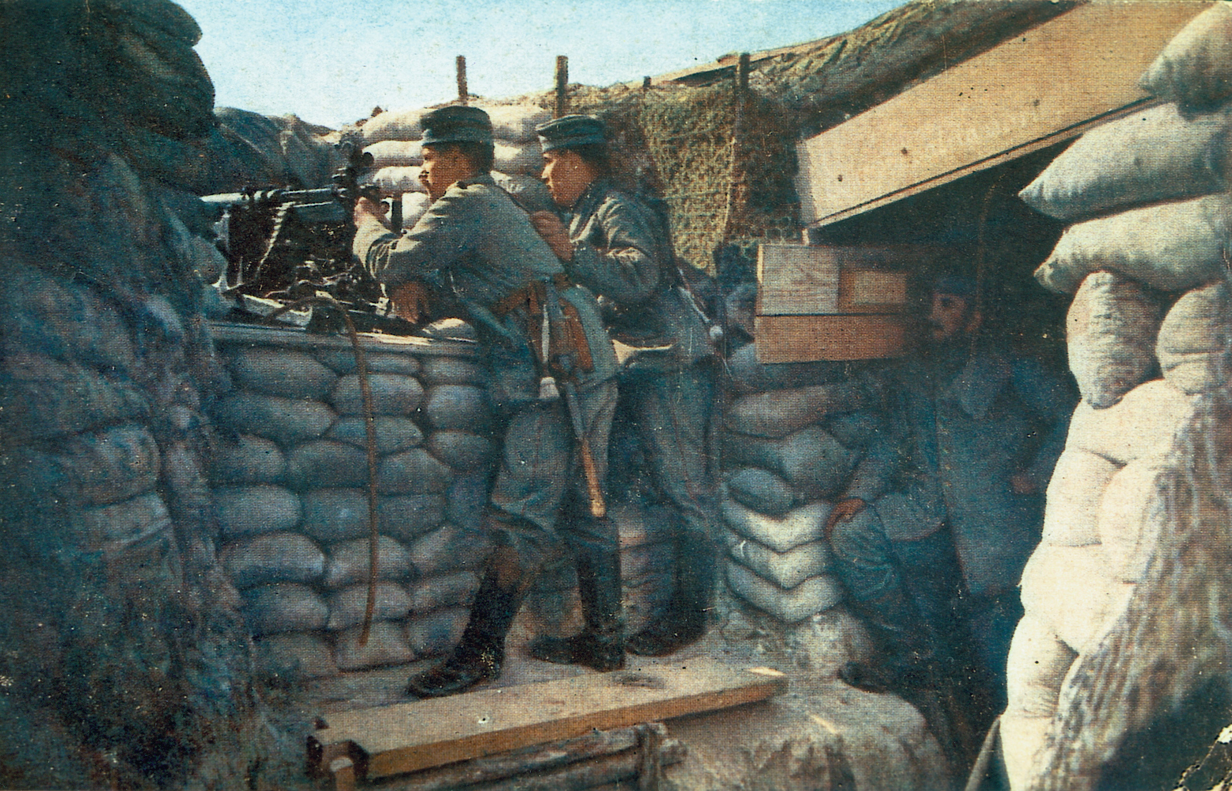 German soldiers pose for a photograph while manning a machine-gun position in a trench.