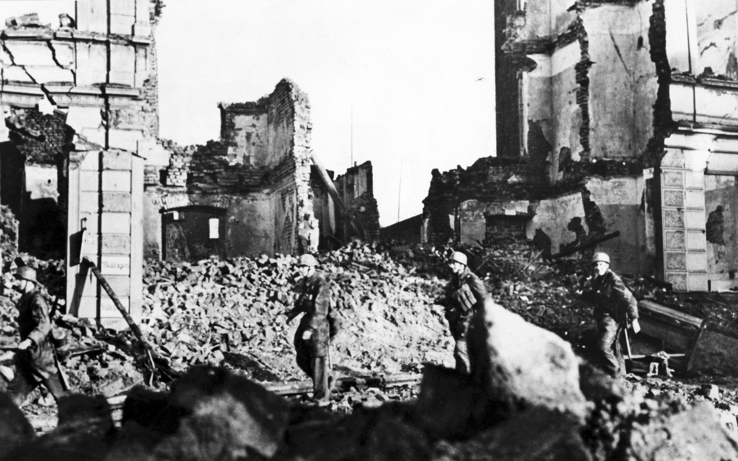 Elite German paratroopers, or fallschirmjager, were among the defenders of Aachen. Here, three of these soldiers are seen scrambling through the rubble of a destroyed building in the city as they move to new defensive positions. (ullstein bild)