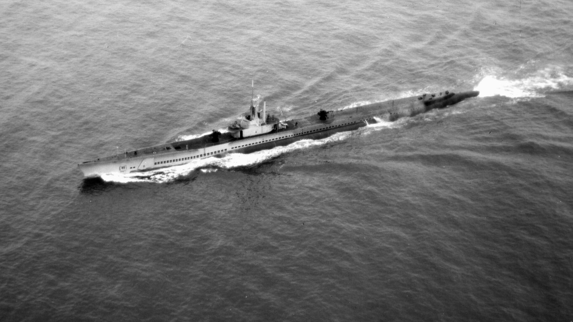 Underway at full speed, the submarine USS Archer-Fish leaves a white wake as it churns along the surface. Archer-Fish survived World War II and was sunk during a torpedo test in the 1960s.